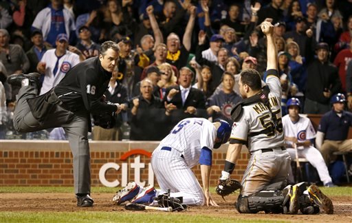 Home plate umpire Mike DiMuro calls Chicago Cubs Nate Schierholtz out at home as Pittsburgh Pirates catcher Russell Martin shows DiMuro the ball during the ninth inning of a baseball game Monday, Sept. 23, 2013, in Chicago. The Pirates won 2-1. (AP Photo/Charles Rex Arbogast) — AP