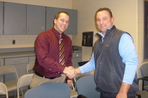 Lucas Rhoades (right,) Tyrone Area School District athletic director, congratulates Jason Wilson (left,) 2004 Tyrone Area High School (TAHS) graduate, for receiving school board approval to fill the vacant TAHS Head Varsity Football Coach position. (The Daily Herald/Meredith Peachey) 