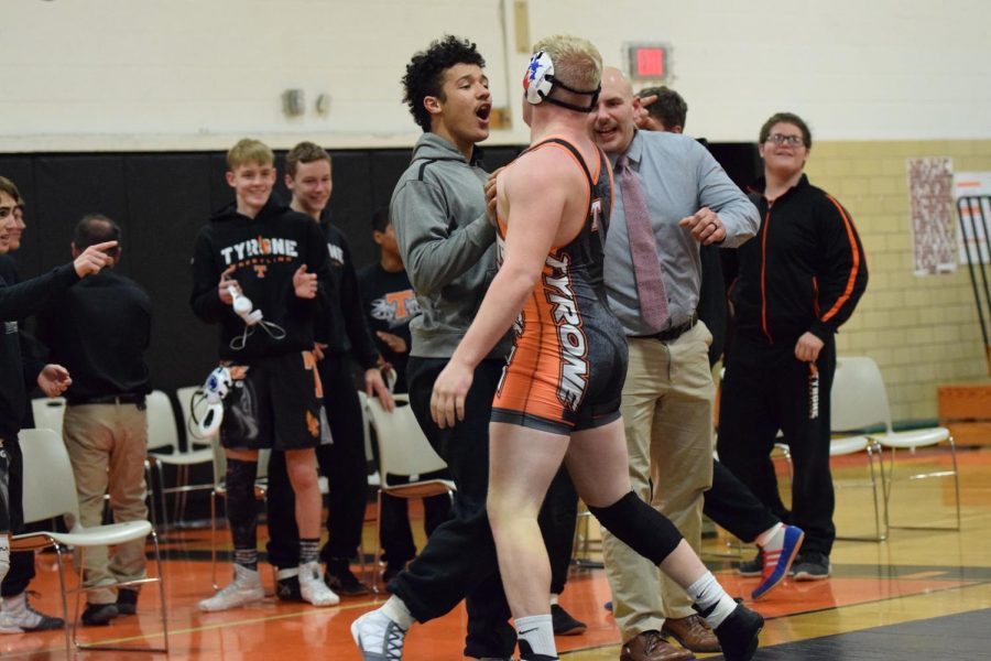Tommy Hicks and Coach Tate congratulate Braeden Ray while wrestlers Parker Allen, Alex Weaver, and Zach Lash look on.