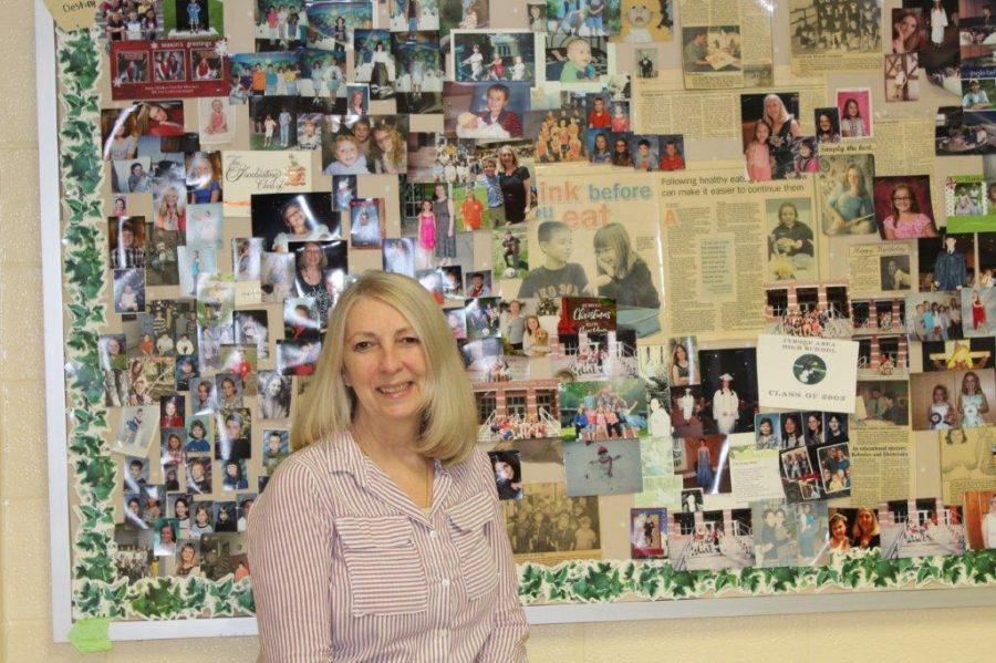 Mrs. Jannette Ober-Lauck in front of her Wall of Fame, where she has posted pictures of her students throughout the years.
