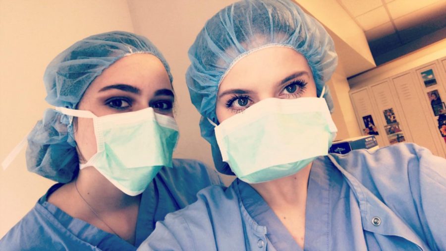 Lexi Kramer and Lauren Ross dressed and ready to observe surgery with Dr. Newlin.