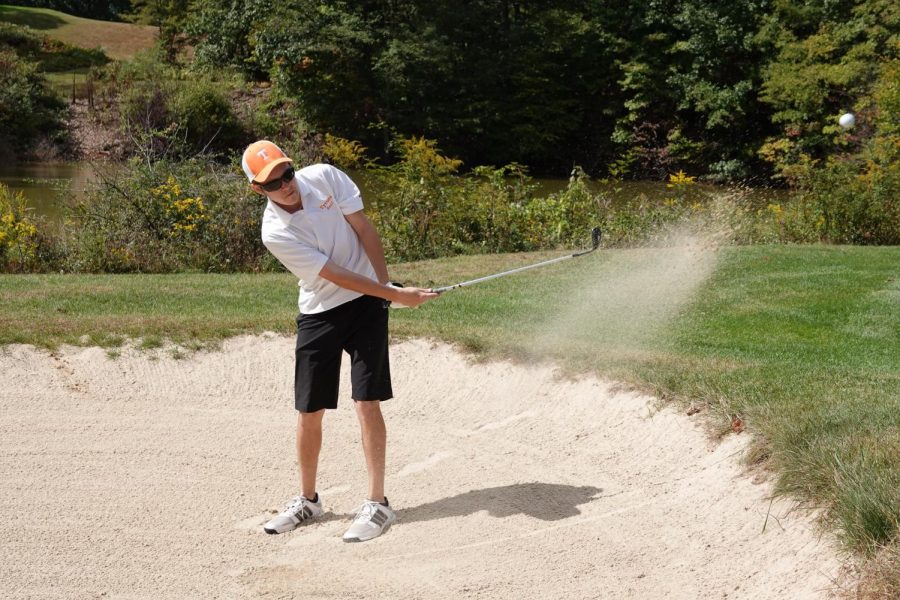 Senior Trey Kyle hitting a bunker shot onto the green.