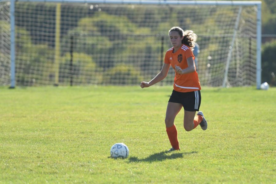 Natalie Saltsgiver dribbling the ball up the field.