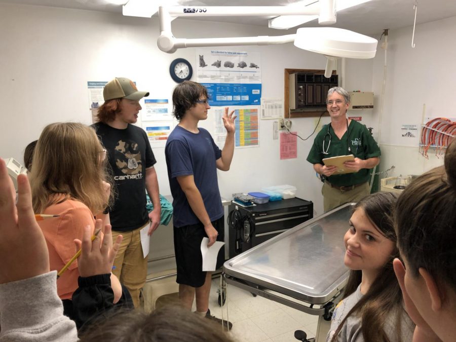 FFA member Brody Rizzo raises his hand to answer questions from Dr. Aquadro (right) during the tour of the exam room at Town and Country Animal Hospital in Warriors Mark