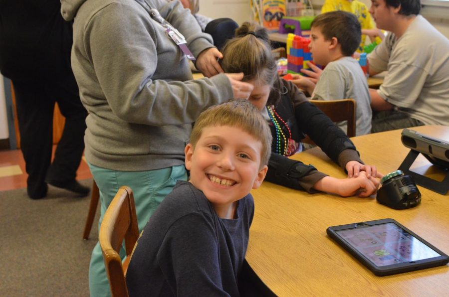 The third-graders clearly enjoy reading and playing games with the high school students from Mrs. Daviss class.