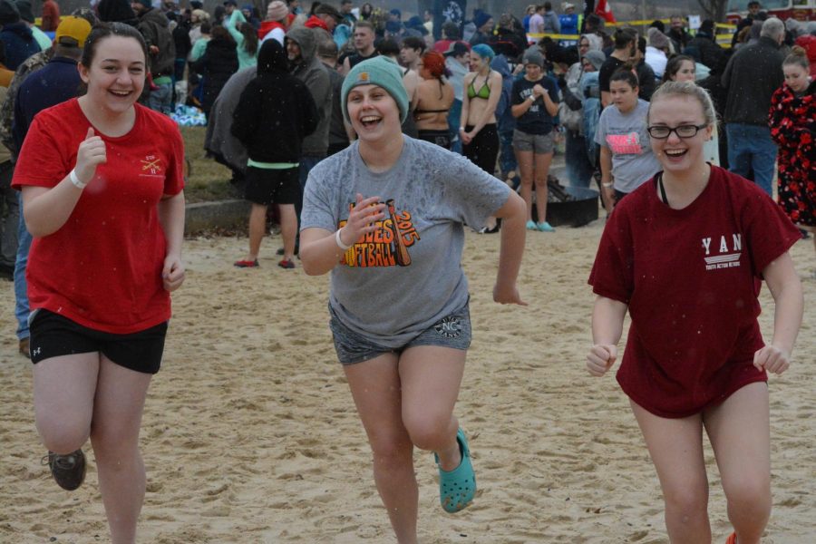 Rilee Barndt, Callie Maceno, and Gracie ball running through the sand before the plunge.