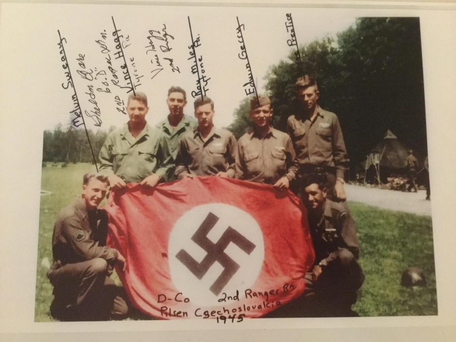 Members of Dog Company, including Vince Hagg and Roy Miles from Tyrone, pose for a photo holding a captured Nazi battle flag in Czechoslovakia in 1945. 