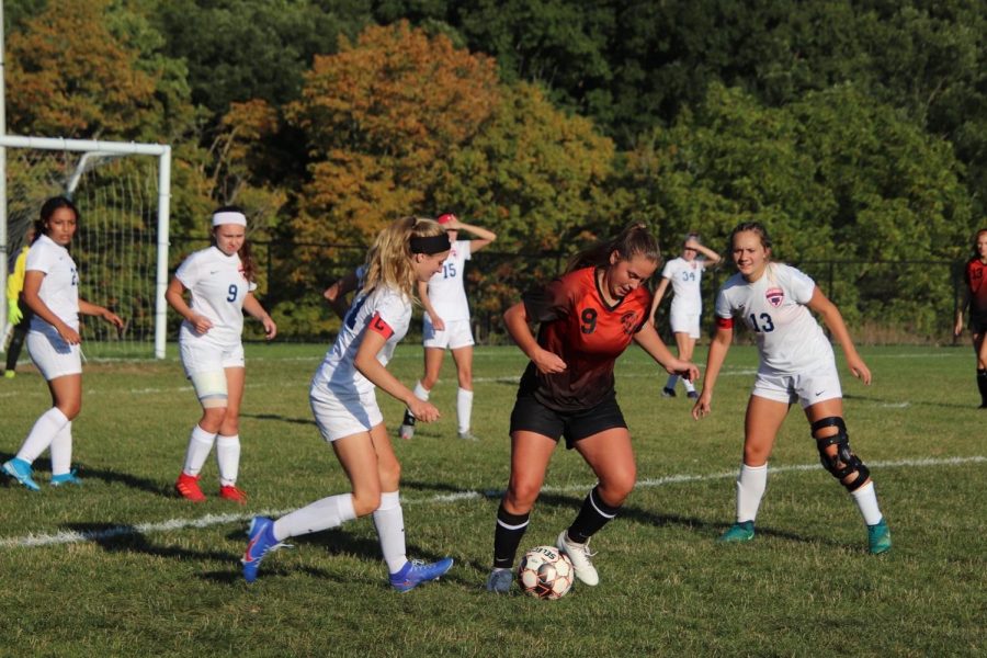 Chloe LaRosa taking a touch on the ball before crossing it to an open player.