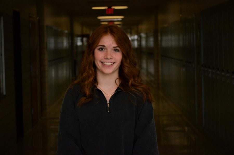 Rylee Fleck smiling in a dark hallway.