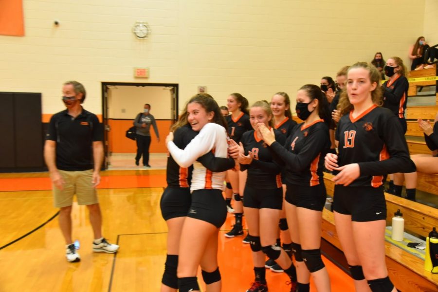 Bauer receives congratulations from senior teammate Mattie Cherry and the rest of the Tyrone varsity squad after recording her 500th kill.