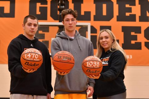 The Gripps: Brandon (2014), Damon (2021) and Nicole (2013) pose in the Tyrone Middle School gym with their 1,000 point basketballs.