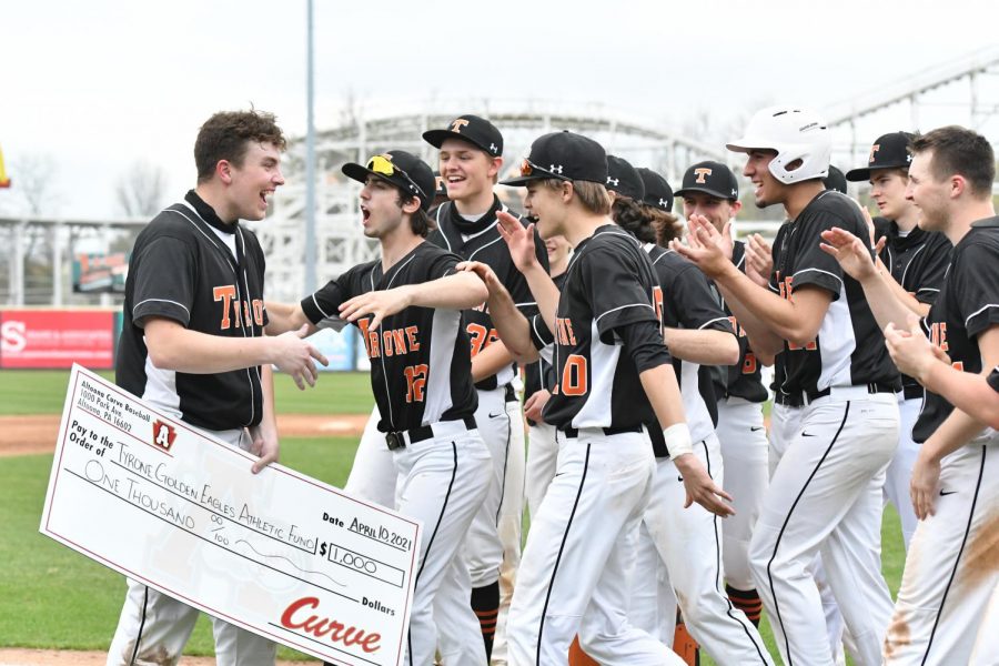 Brendan Grazier holds his stacks of cash while the team runs to congratulate him