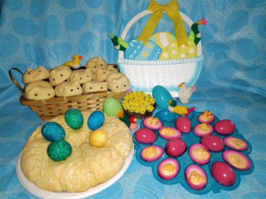 Easter eggs and Easter birds flocking around rabbit-shaped rolls, deviled-pickled eggs, and Easter egg bread.