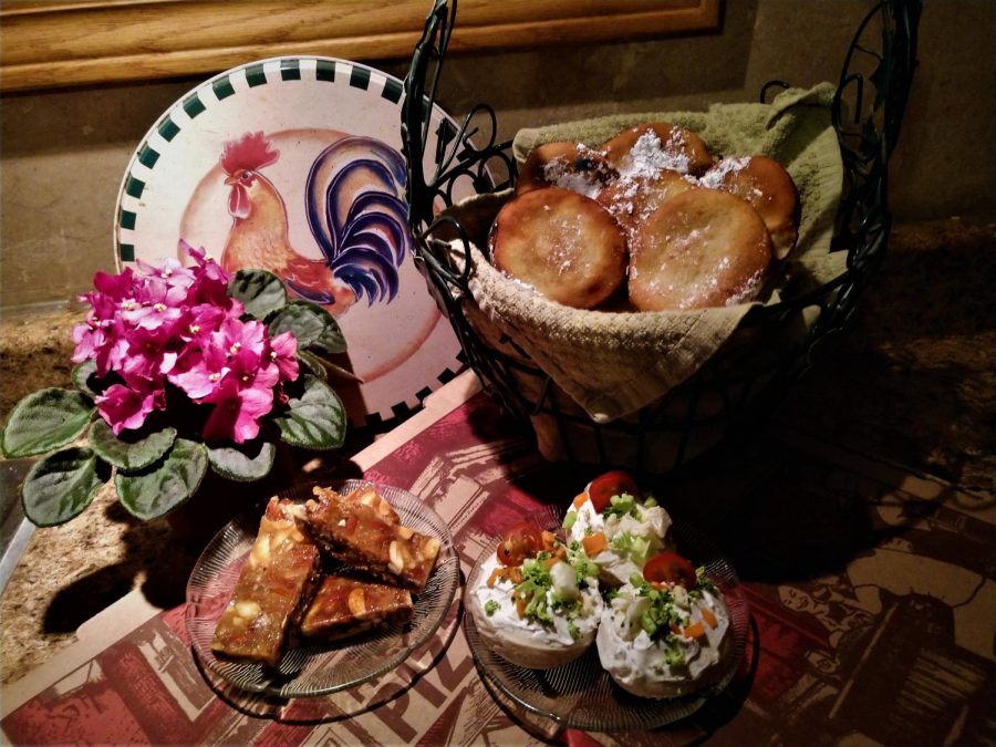 A beignet basket towering above a colourful display of turron slices and bite-sized vegetable pizzas.