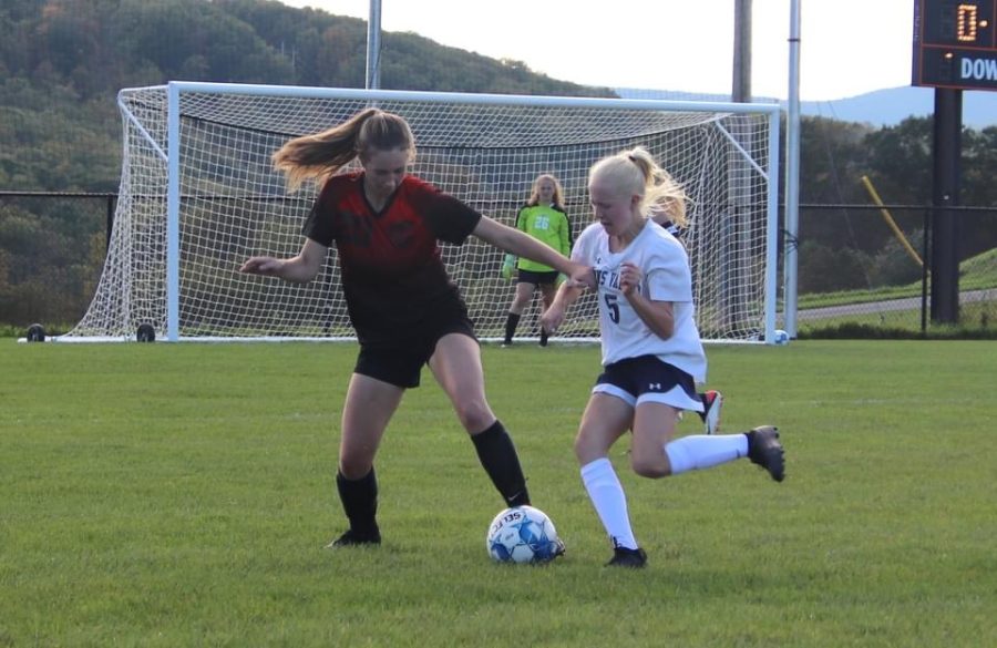 Junior Eliza Vance taking the ball away from the opposing player.