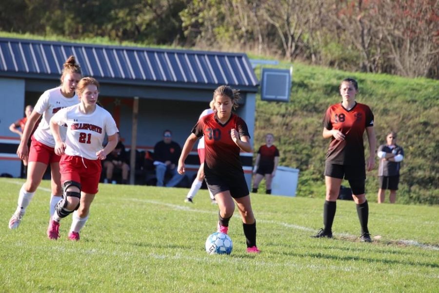 Sophomore Annie Bardell dribbling the ball around the mid-field.