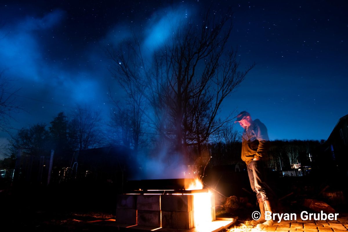 Gruber tends to the fire late into the night in order to boil the maple sap down into maple syrup. 