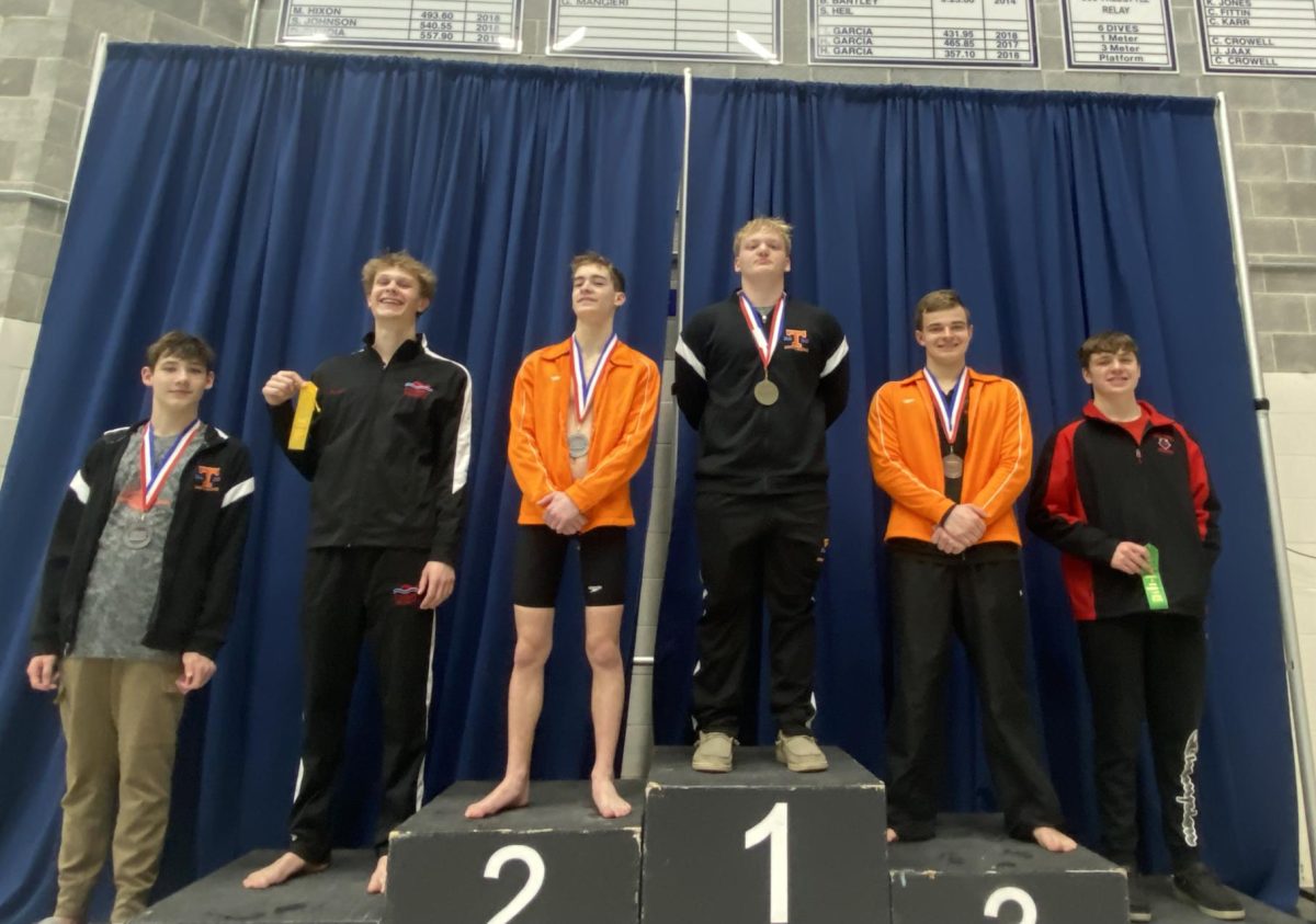 Junior Lucas Bonsell stands on top of the podium for his first place swim in the 100 butterfly (photo courtesy of Nicole Bonsell)