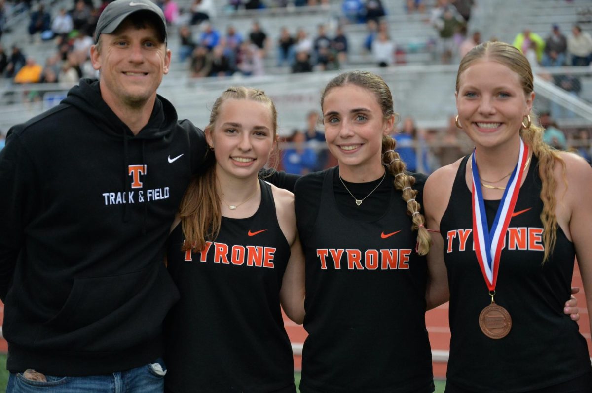 Coach Kanuch with three Tyrone athletes who qualified for states last spring; Sarah Chichester, Nicole Ramsey, and Becca Lewis