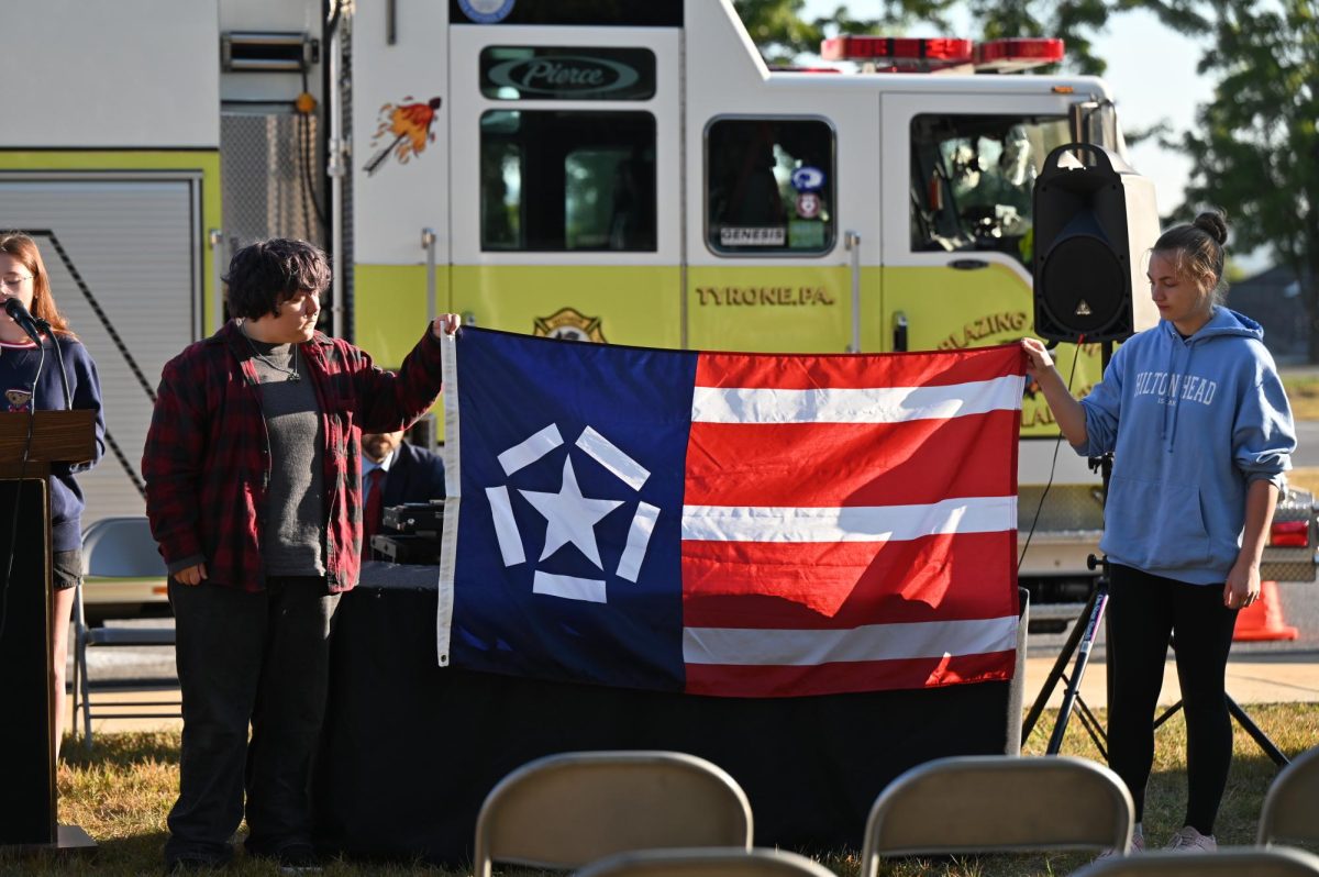 Freedom Flag Committee members Marshall George and Pyper Sparklin hold the Freedom Flag at the beginning of the flag raising ceremony on September 11, 2025.