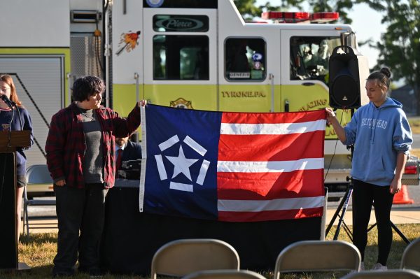 Freedom Flag Committee members Marshall George and Pyper Sparklin hold the Freedom Flag at the beginning of the flag raising ceremony on September 11, 2025.