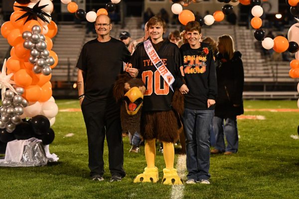 Miller, seen here with his parents  Adam and Ashley Miller on senior night in 2025, was the Tyrone Eagle mascot for five years, starting in eighth grade, 